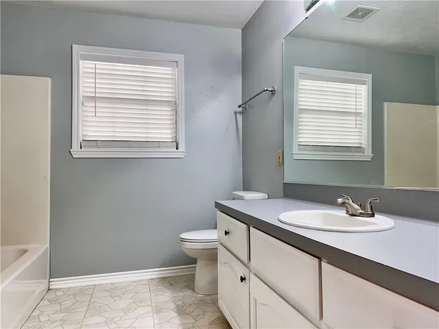 a bathroom with a sink toilet and mirror