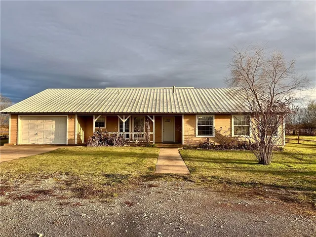 a view of a house with a yard and sitting area