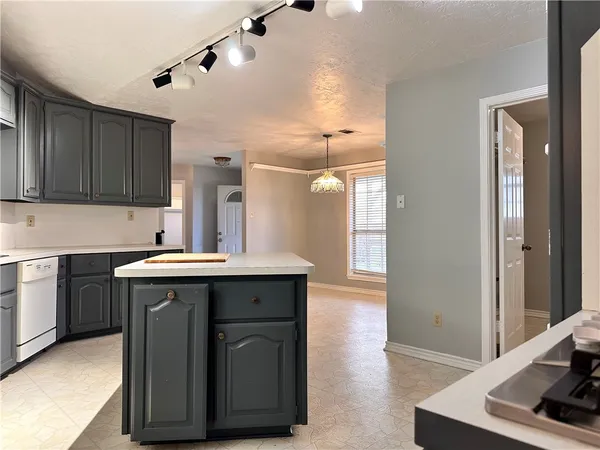 a kitchen with a sink cabinets and wooden floor