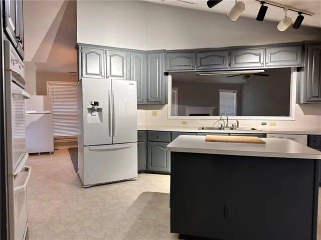 a kitchen with stainless steel appliances a sink and a refrigerator