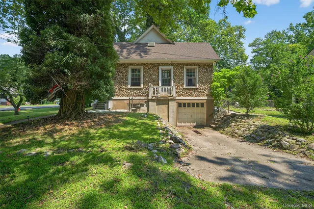 a front view of a house with yard and green space
