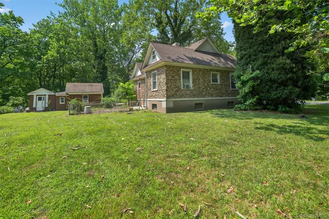 a front view of a house with a garden and trees