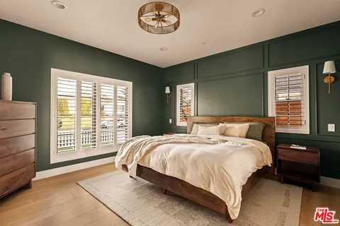 a bedroom with a bed and a large window