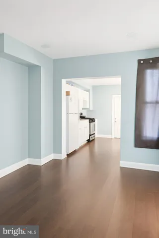 a view of empty room with wooden floor and window