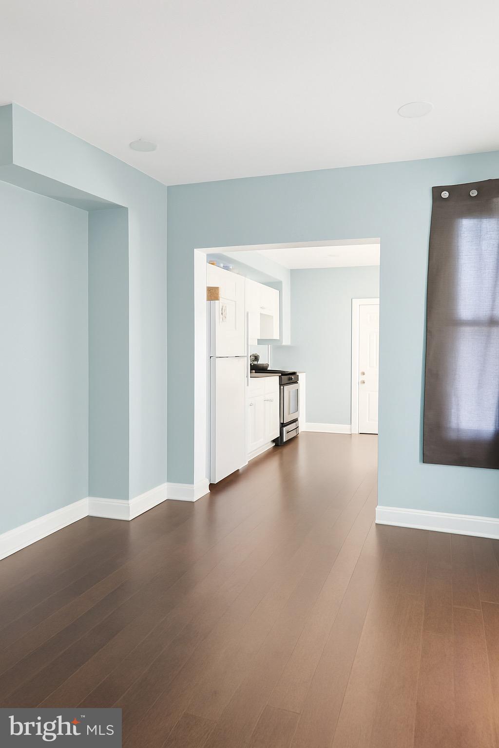 215 South Calhoun Street Baltimore, MD 21223 - Photo 4 of 15 a view of empty room with wooden floor and window