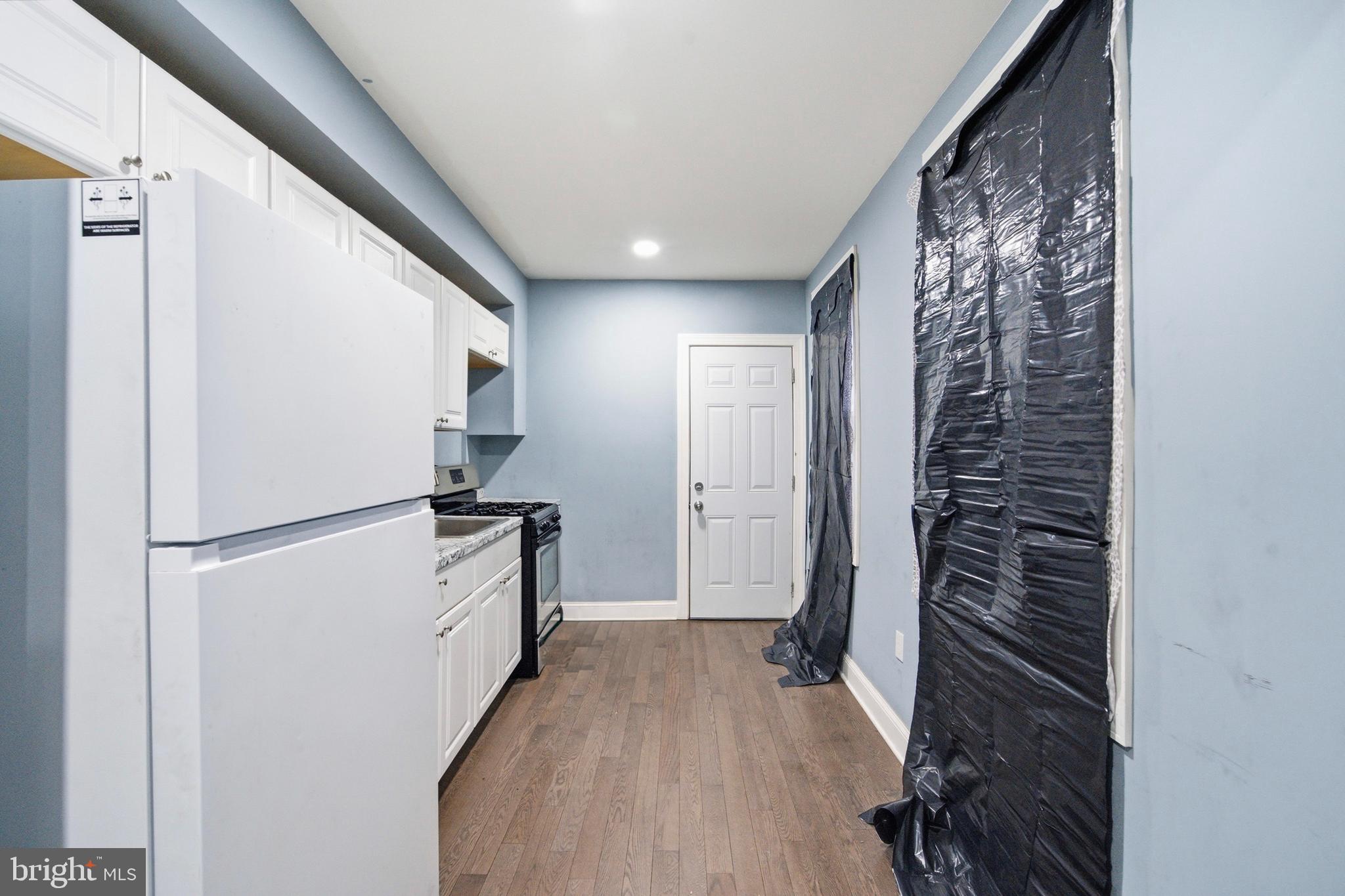 215 South Calhoun Street Baltimore, MD 21223 - Photo 6 of 15 a kitchen with a refrigerator and a stove