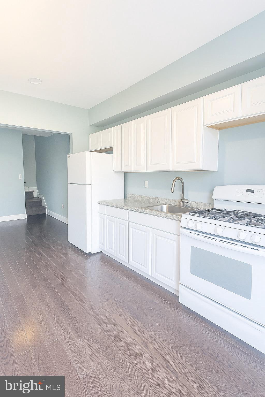 215 South Calhoun Street Baltimore, MD 21223 - Photo 6 of 15 a kitchen with a sink cabinets and wooden floor