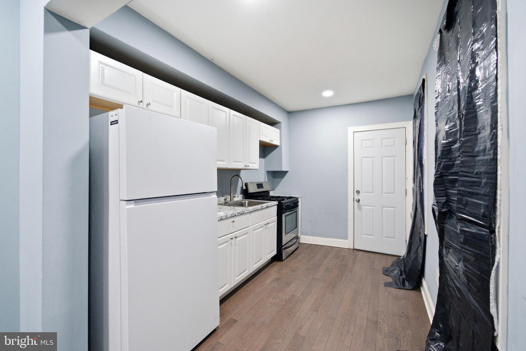 215 South Calhoun Street Baltimore, MD 21223 - Photo 7 of 15 a kitchen with a refrigerator and a stove