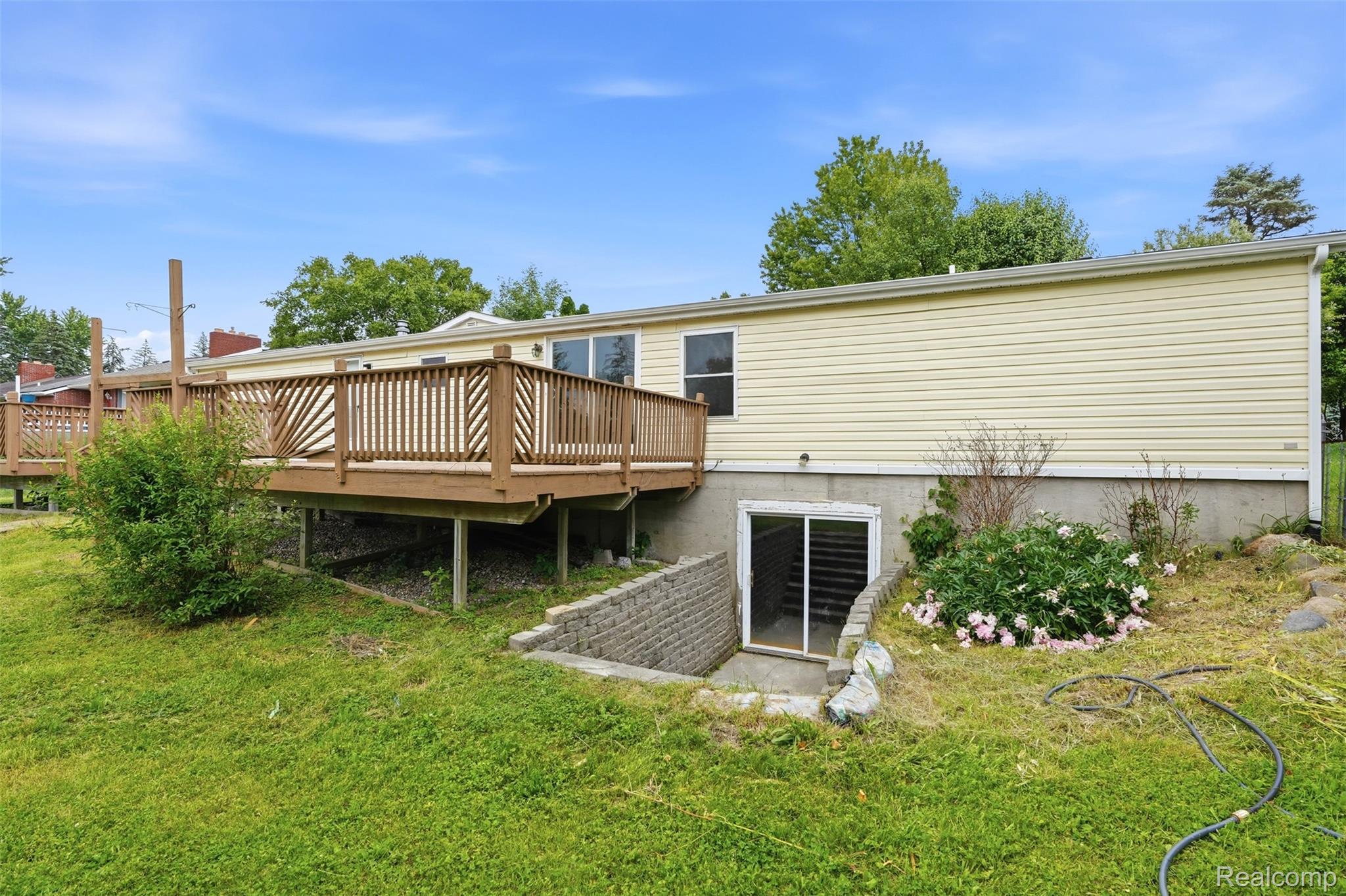 4420 Dublin Road Burton, MI 48529 - Photo 35 of 56 Rear exterior featuring a spacious wood-finish deck with decorative railings and an exterior staircase