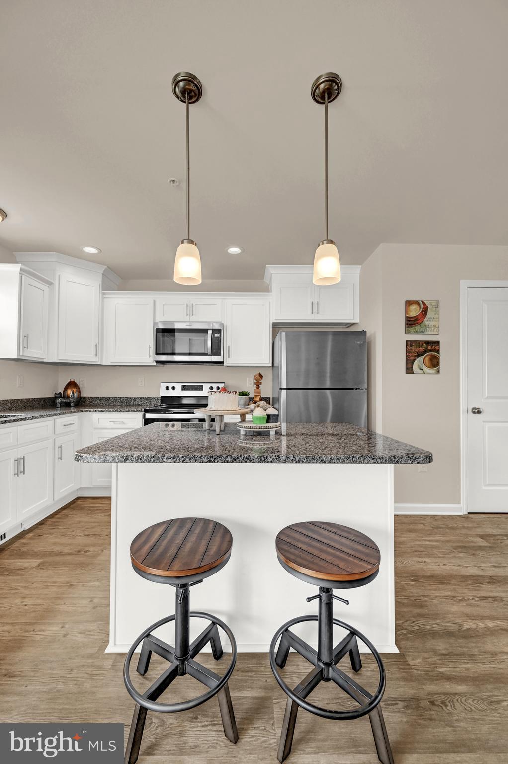 1 Landing Place, Unit 1 York, PA 17408 - Photo 14 of 35 a kitchen with stainless steel appliances granite countertop a stove a refrigerator a kitchen island a dining table and chairs