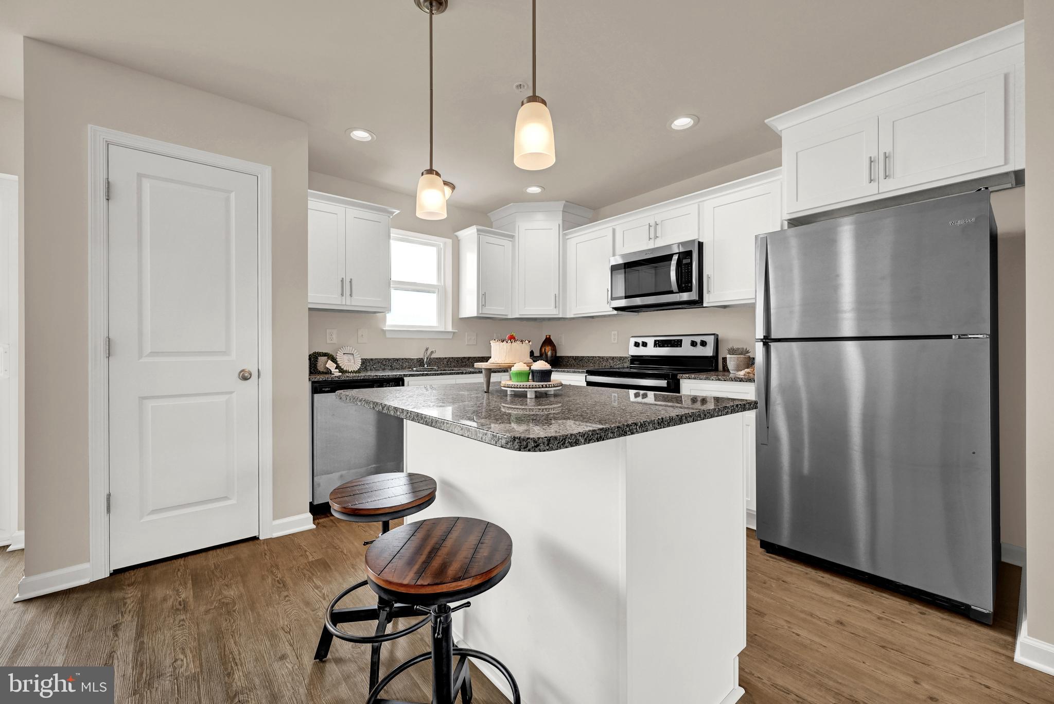 1 Landing Place, Unit 1 York, PA 17408 - Photo 10 of 35 a kitchen with stainless steel appliances granite countertop a refrigerator a stove a sink and a microwave with wooden floor