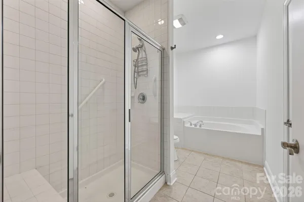 an empty room with wooden floor chandelier fan and windows