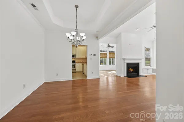 a view of a room with wooden floor fireplace and windows