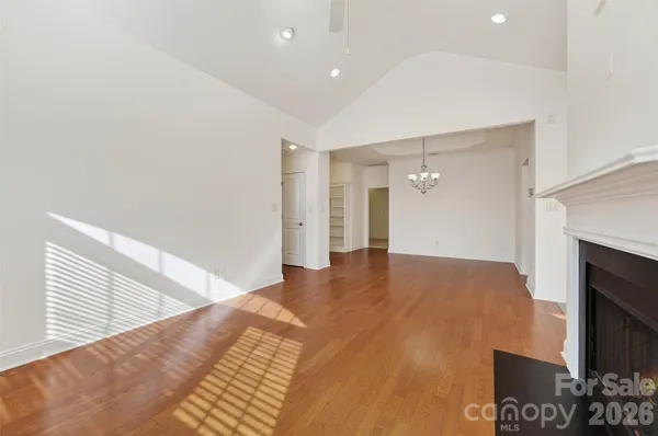 a view of an empty room and a kitchen