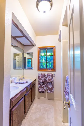 a spacious bathroom with a granite countertop sink a mirror and a bathtub