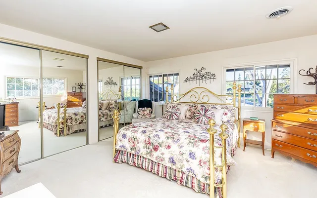 a bedroom with a large bed and a chandelier