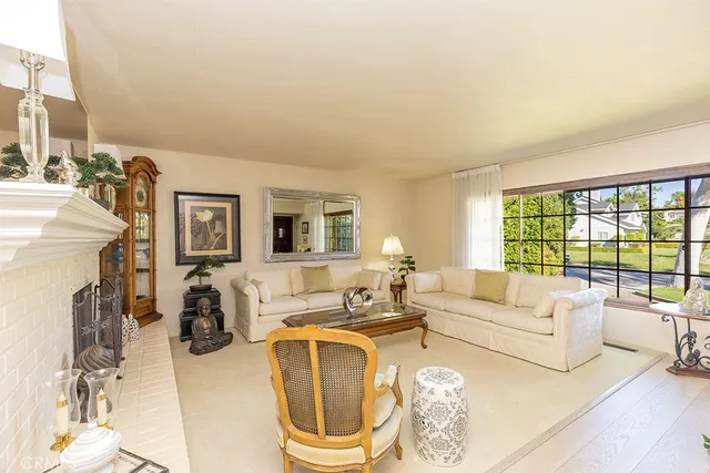 a living room with furniture a fireplace and a large window