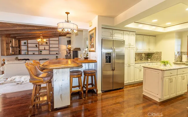 a kitchen with stainless steel appliances kitchen island granite countertop a table chairs and chandelier