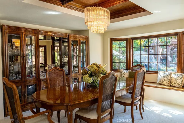 a dining room with furniture a chandelier and window