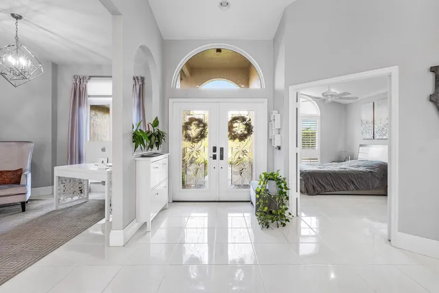 a living room with furniture a chandelier and a flat screen tv