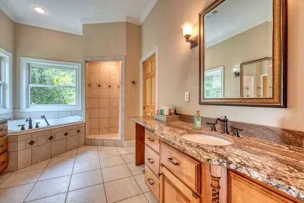 a spacious bedroom with a bed and a chandelier