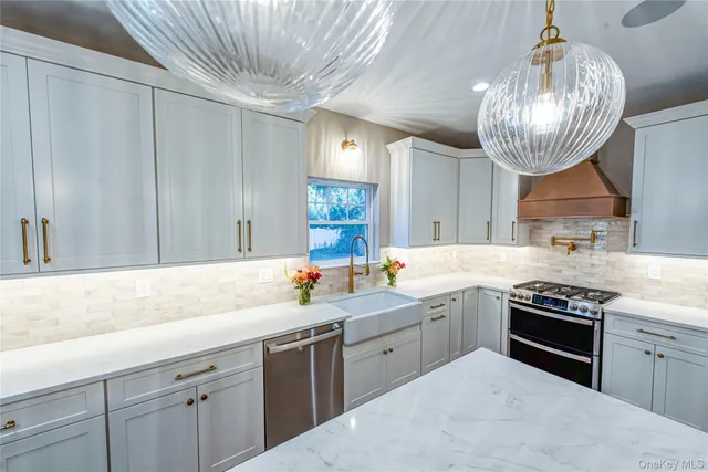 a kitchen with stainless steel appliances granite countertop a sink a stove a washer dryer and cabinets