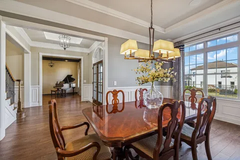 a dining room with furniture a chandelier and wooden floor