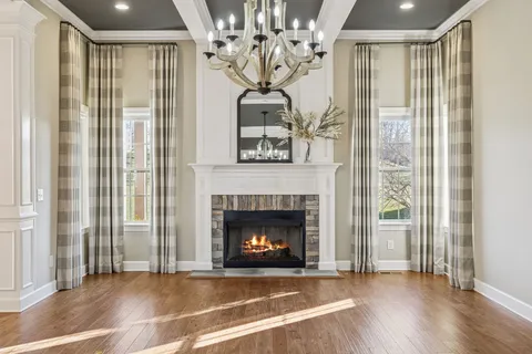 a view of a livingroom with a fireplace wooden floor and windows
