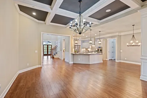 a kitchen with stainless steel appliances granite countertop a refrigerator a stove a sink dishwasher and white cabinets with wooden floor