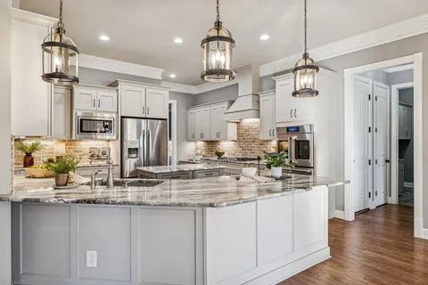 a kitchen with granite countertop a stove and a wooden floors