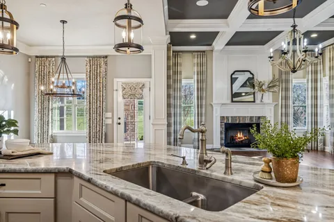 a large white kitchen with a large window and stainless steel appliances