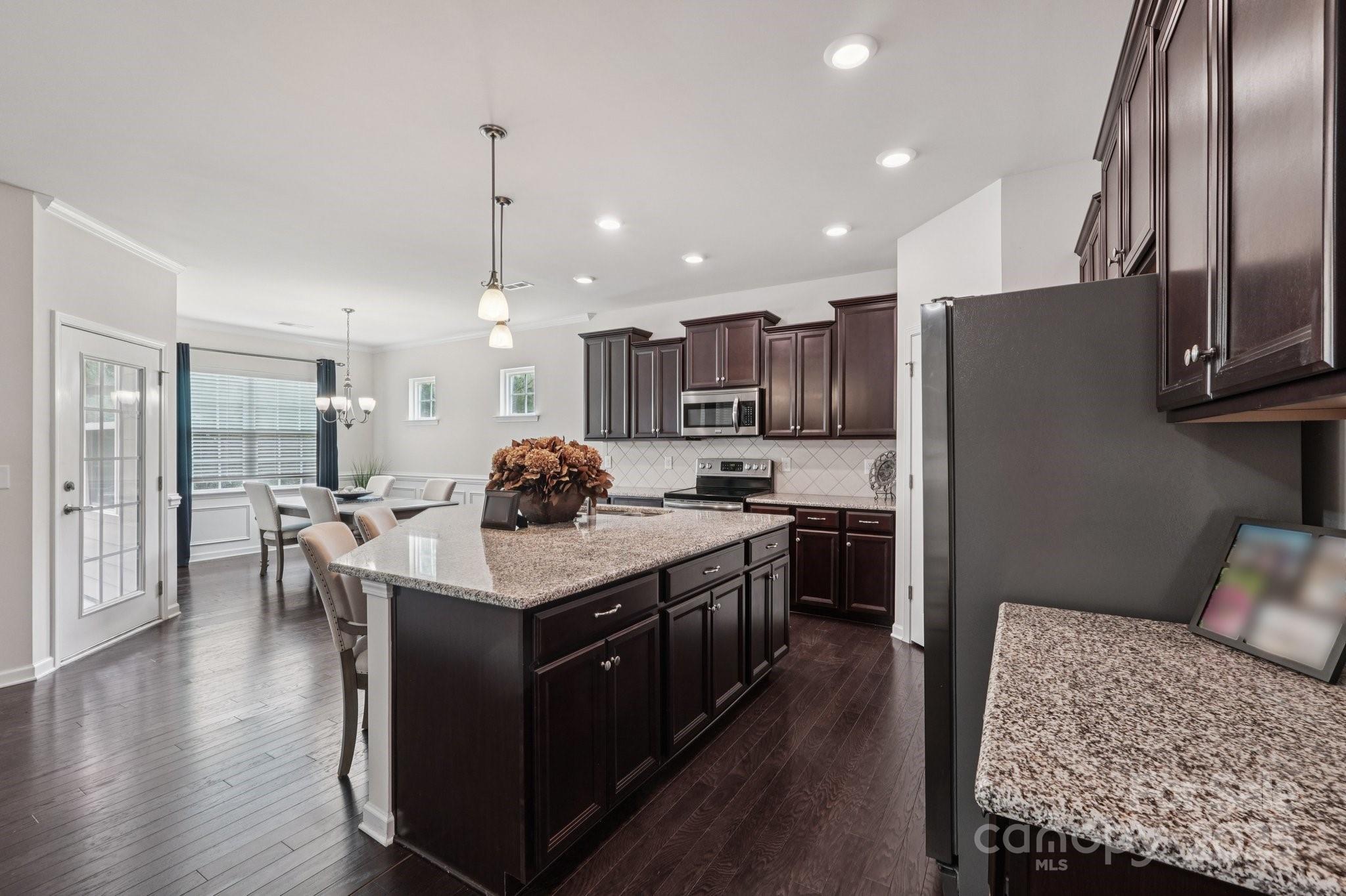 8058 Asher Chase Trail Lancaster, SC 29720 - Photo 5 of 48 a kitchen with stainless steel appliances granite countertop a stove a refrigerator a oven and a sink with wooden floor