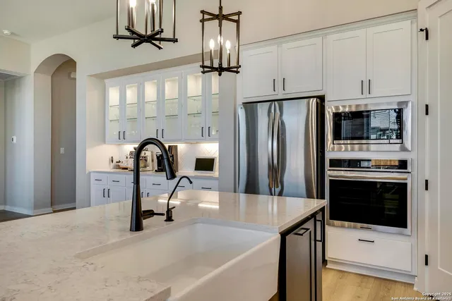 a kitchen with stainless steel appliances kitchen island a refrigerator sink and cabinets