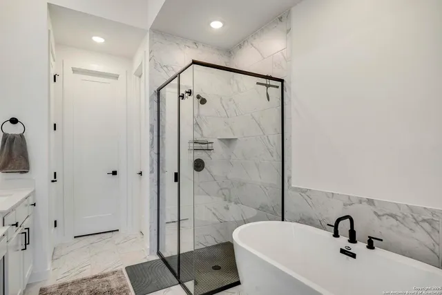 a bathroom with a tub shower sink and mirror