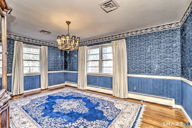 a view of a livingroom with wooden floor and a chandelier