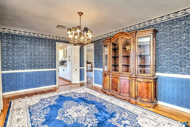 a dining room with furniture a chandelier and wooden floor