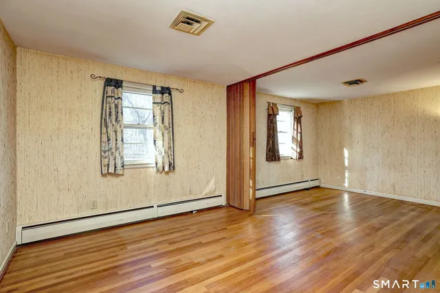 a view of an empty room with wooden floor
