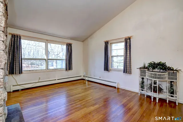 a living room with a fireplace and wooden floor