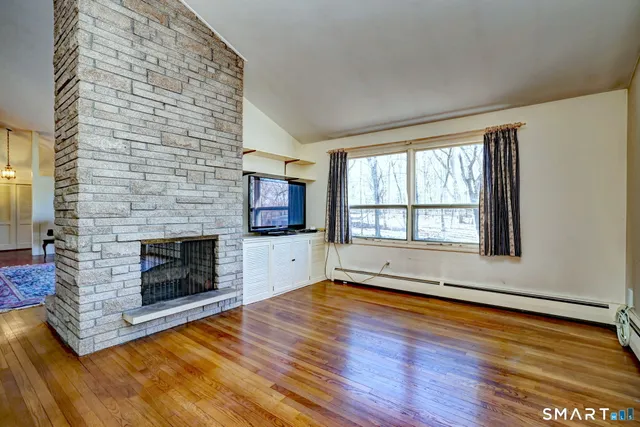 a view of a livingroom with a fireplace and window