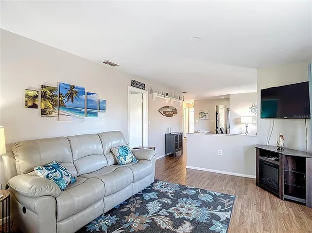 a living room with hardwood floor and large windows