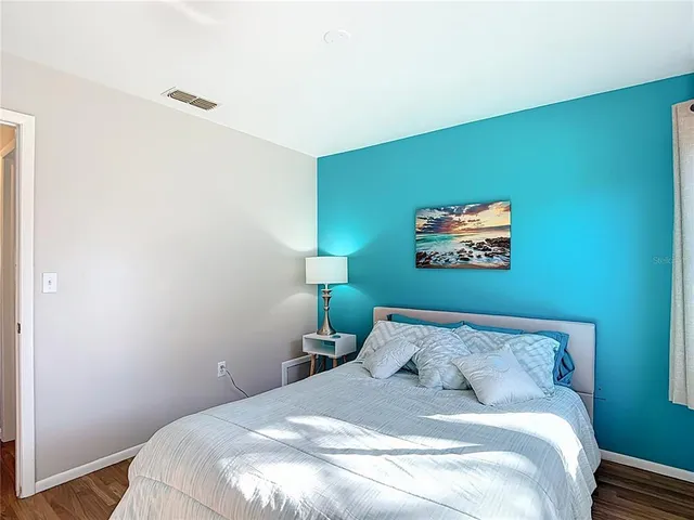 a bedroom with a bed and wooden floor
