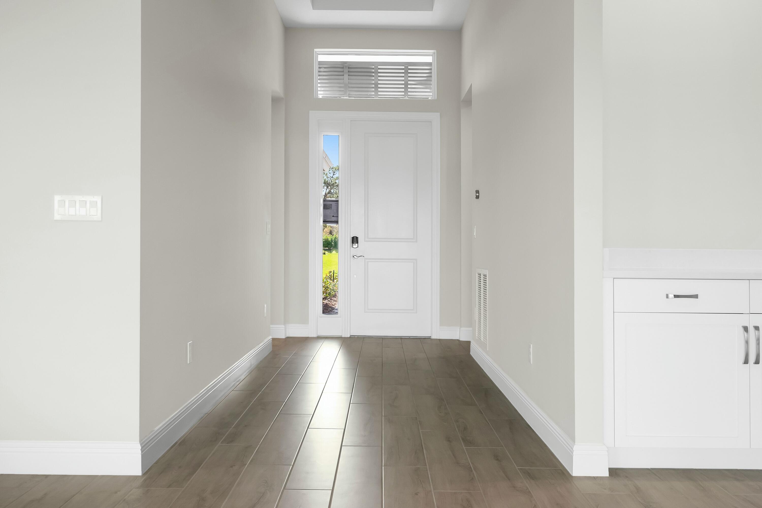 6382 High Pointe Circle Vero Beach, FL 32967 - Photo 5 of 55 a view of a hallway with wooden floor and a bathroom