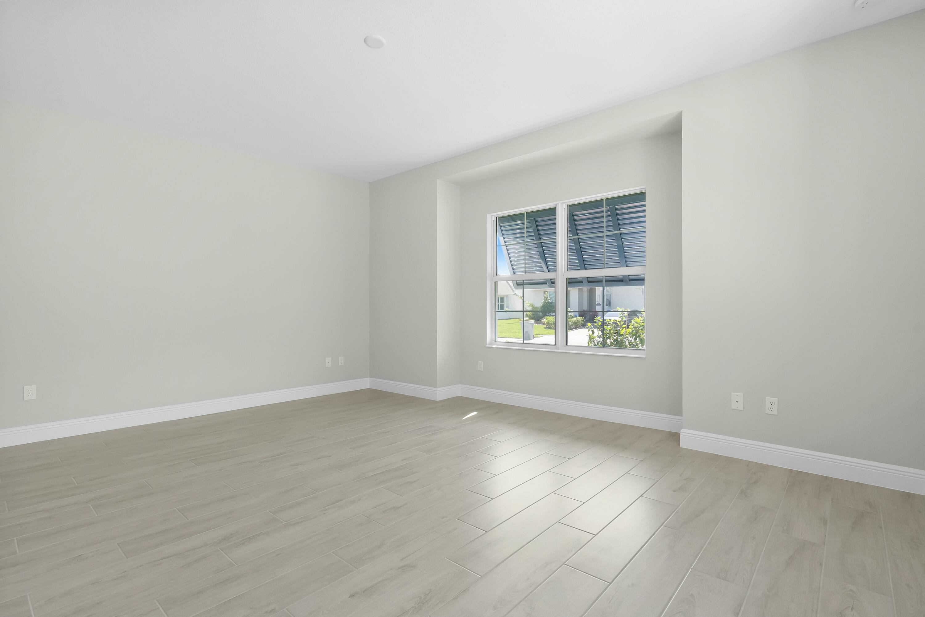6382 High Pointe Circle Vero Beach, FL 32967 - Photo 10 of 55 an empty room with wooden floor and windows