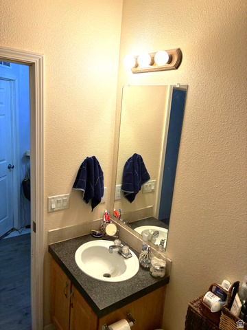 547 East 2000th Street North Vernal, UT 84078 - Photo 29 of 50 Bathroom vanity with an integrated sink, granite-look countertop, and wood-finish cabinetry