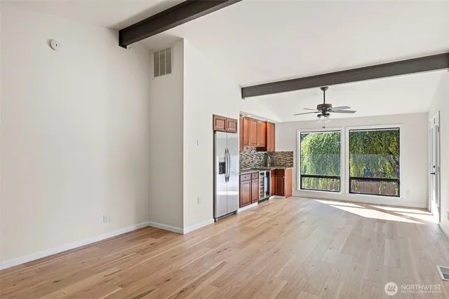 a view of a room with wooden floor and a ceiling fan
