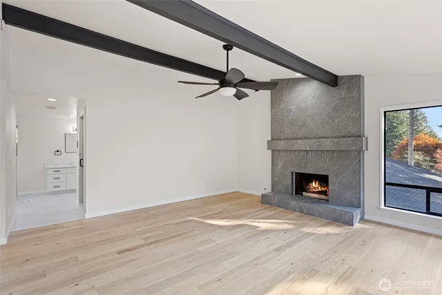 a view of empty room with wooden floor and fireplace