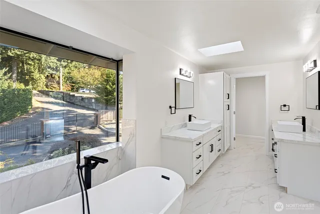 a bathroom with double vanity and a bathtub