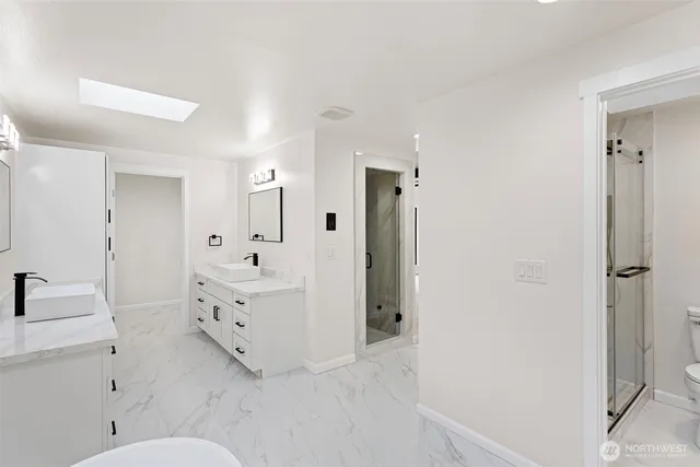 a bathroom with a sink toilet vanity and shower