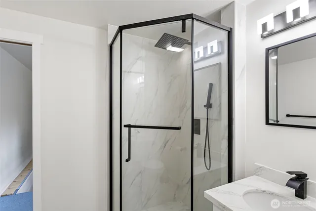 a bathroom with a glass shower door and a mirror