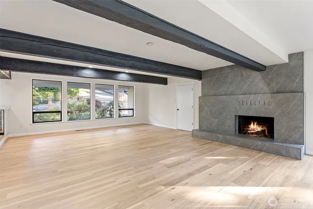 a view of empty room with wooden floor and fireplace